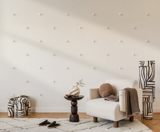 Modern living room with Dun wall art, a white armchair, side table, and decorative items.