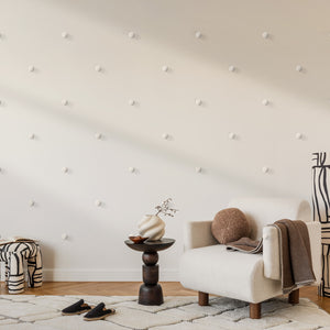 Modern living room with Dun wall art, a white armchair, side table, and decorative items.