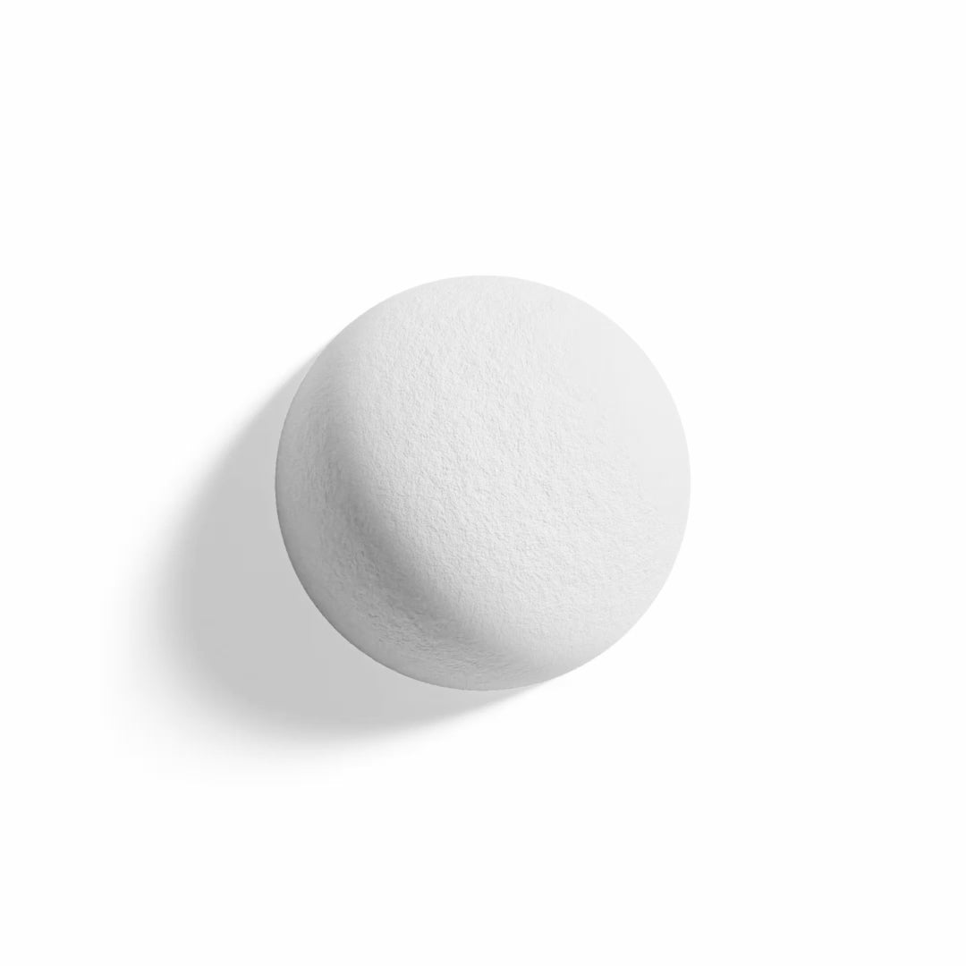Shadow plays across the surface of a white dome form attached to the wall. 